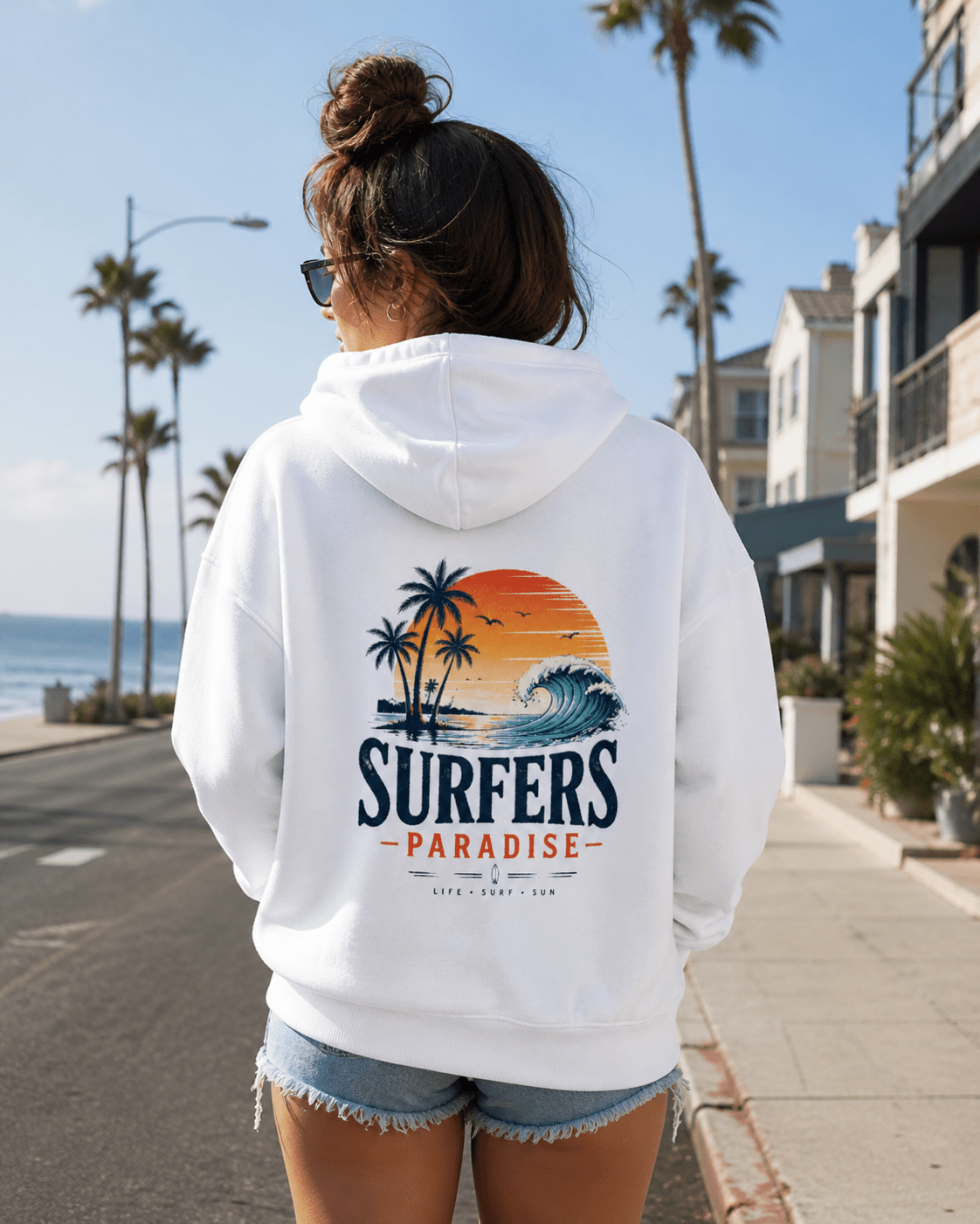 White pullover hoodie back view with hood; surf-themed print with palms and ocean wave