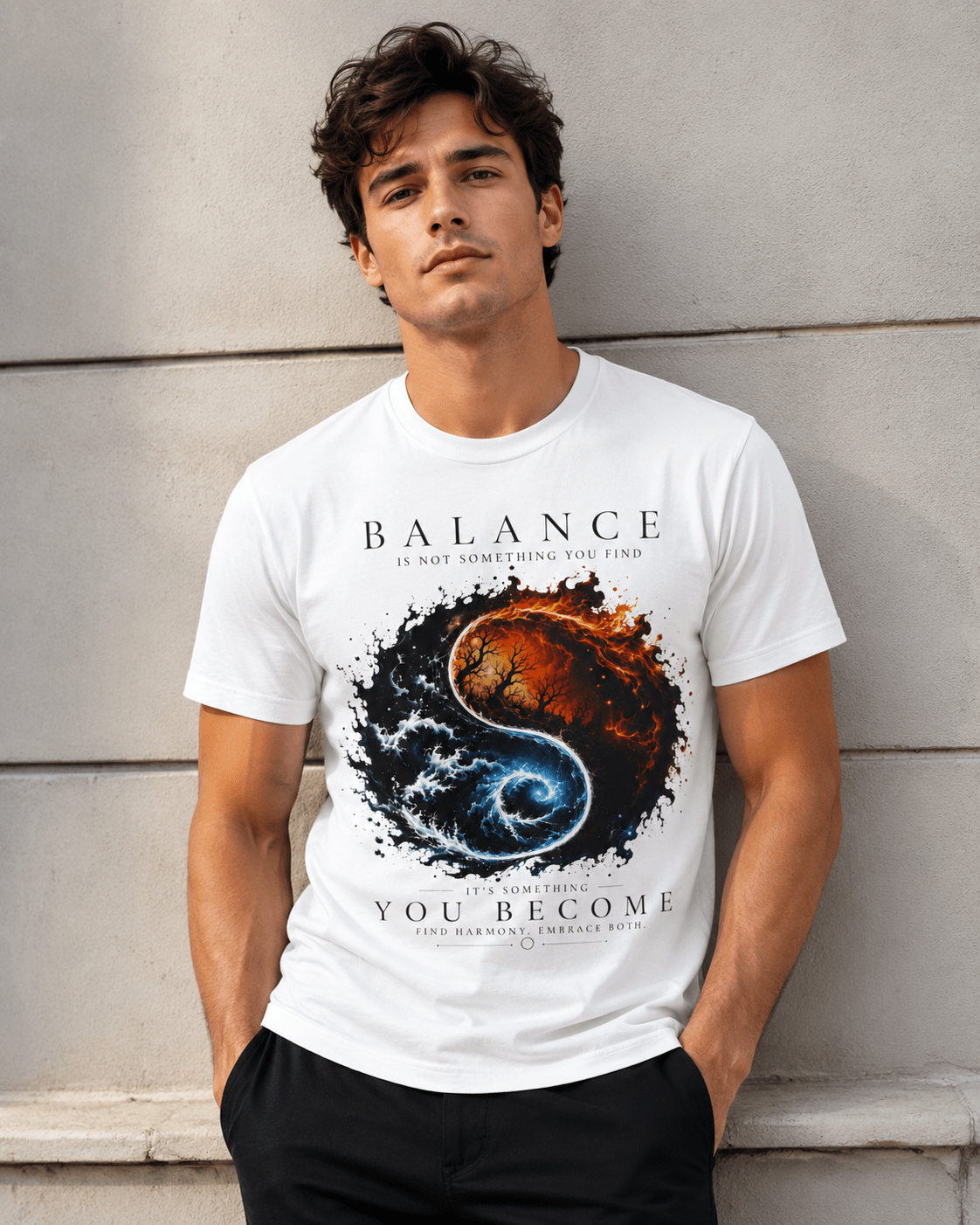 A man wearing a white graphic t-shirt with a yin-yang design featuring a burning planet and a swirling blue galaxy, with the text 'BALANCE IS NOT SOMETHING YOU FIND YOU BECOME' leaning against a light gray concrete wall.