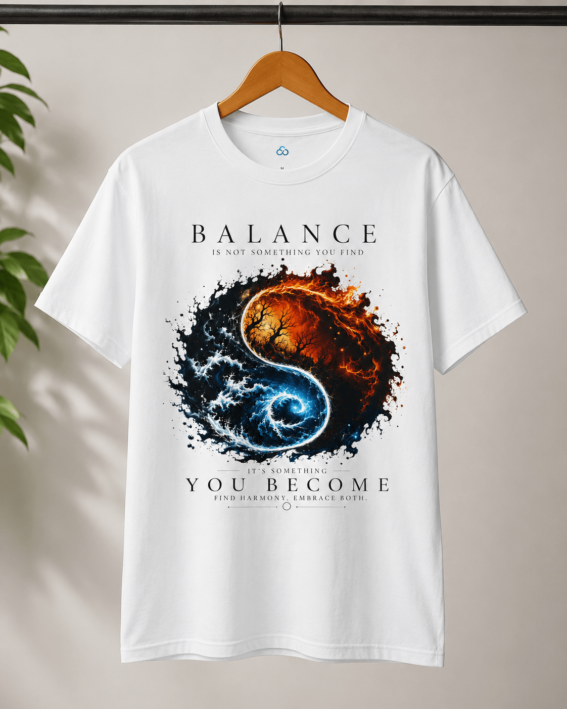 A white short-sleeve t-shirt hanging on a wooden hanger against a light beige wall, featuring a large yin-yang style graphic with a fiery orange-red half and a swirling blue half, with the text 'BALANCE IS NOT STATIC STANDING, YOU ARE FADING' and 'YOU BECOME' below.
