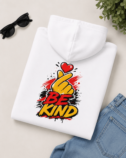 White hoodie folded with centered 'Be Kind' heart-and-hand graphic