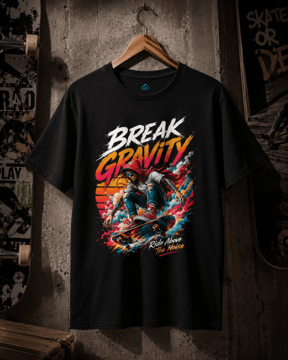 A black graphic t-shirt hanging on a wooden hanger against a rustic concrete wall. The shirt features a colorful graphic of a skateboarder with the text 'BREAK GRAVITY' and 'Ride Above the Noise' in stylized white, orange, and yellow lettering.