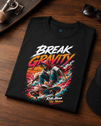 A black graphic t-shirt laid flat on a wooden surface, featuring a colorful skateboarder design with the text 'BREAK GRAVITY' and 'Ride Above The Noise'.