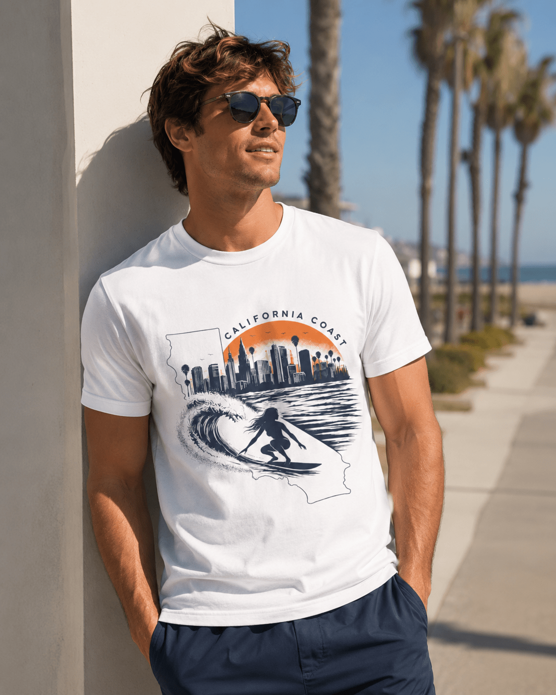 White T-shirt with California coast skyline and wave surfer artwork, worn by a man