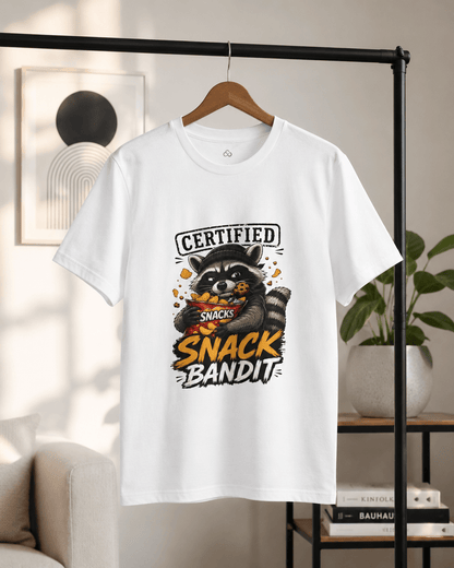 White crew-neck T-shirt hanging on a wooden hanger, raccoon 'Snack Bandit' print