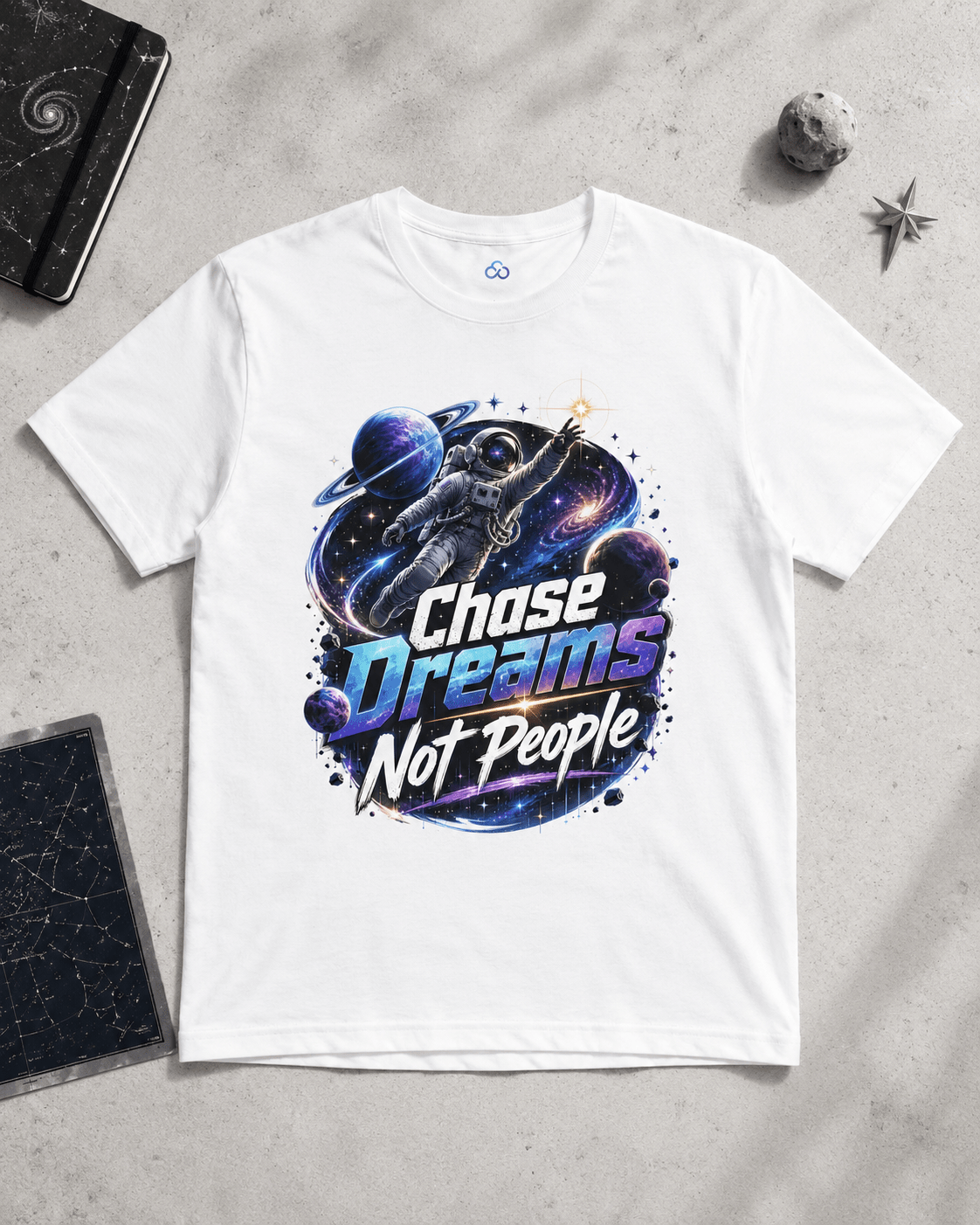 White graphic T-shirt with astronaut, “Chase Dreams Not People” print on chest.