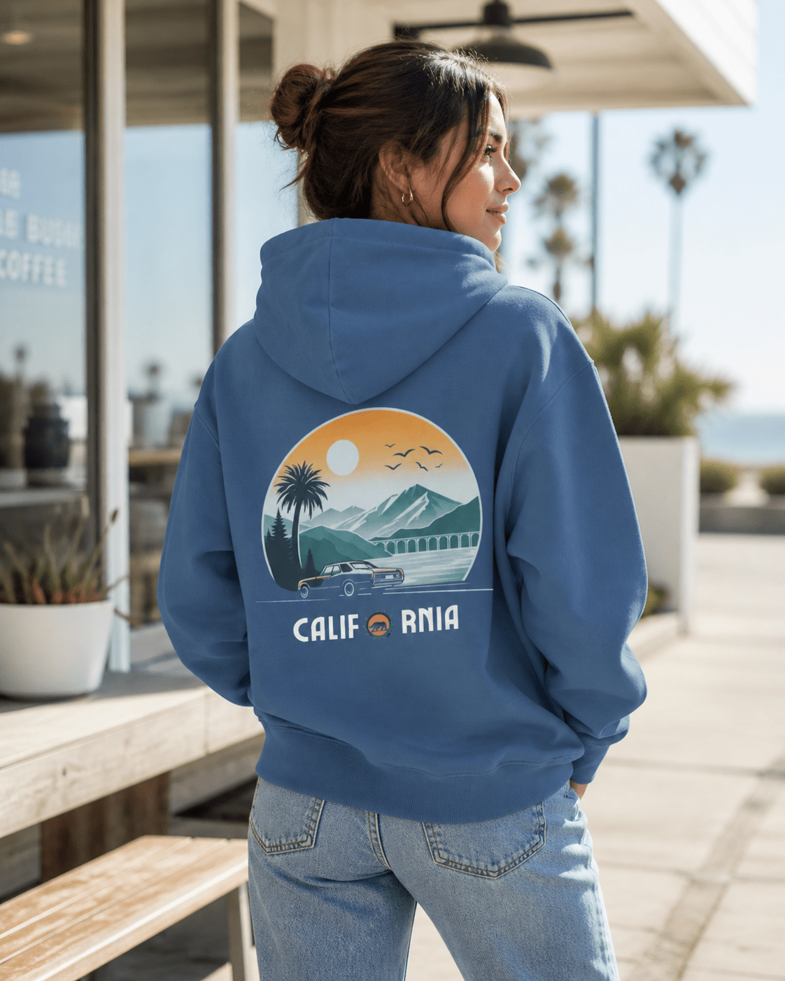 Person wearing a blue hoodie with a scenic design and 'California' text, standing outdoors.