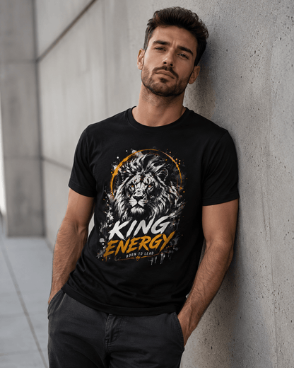 Man wearing a black t-shirt with a lion graphic and 'King Energy' text against a concrete wall.