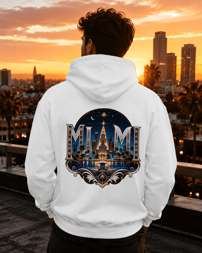 A man viewed from behind wearing a white hoodie with a large, detailed Miami skyline graphic on the back, set against a sunset cityscape background.