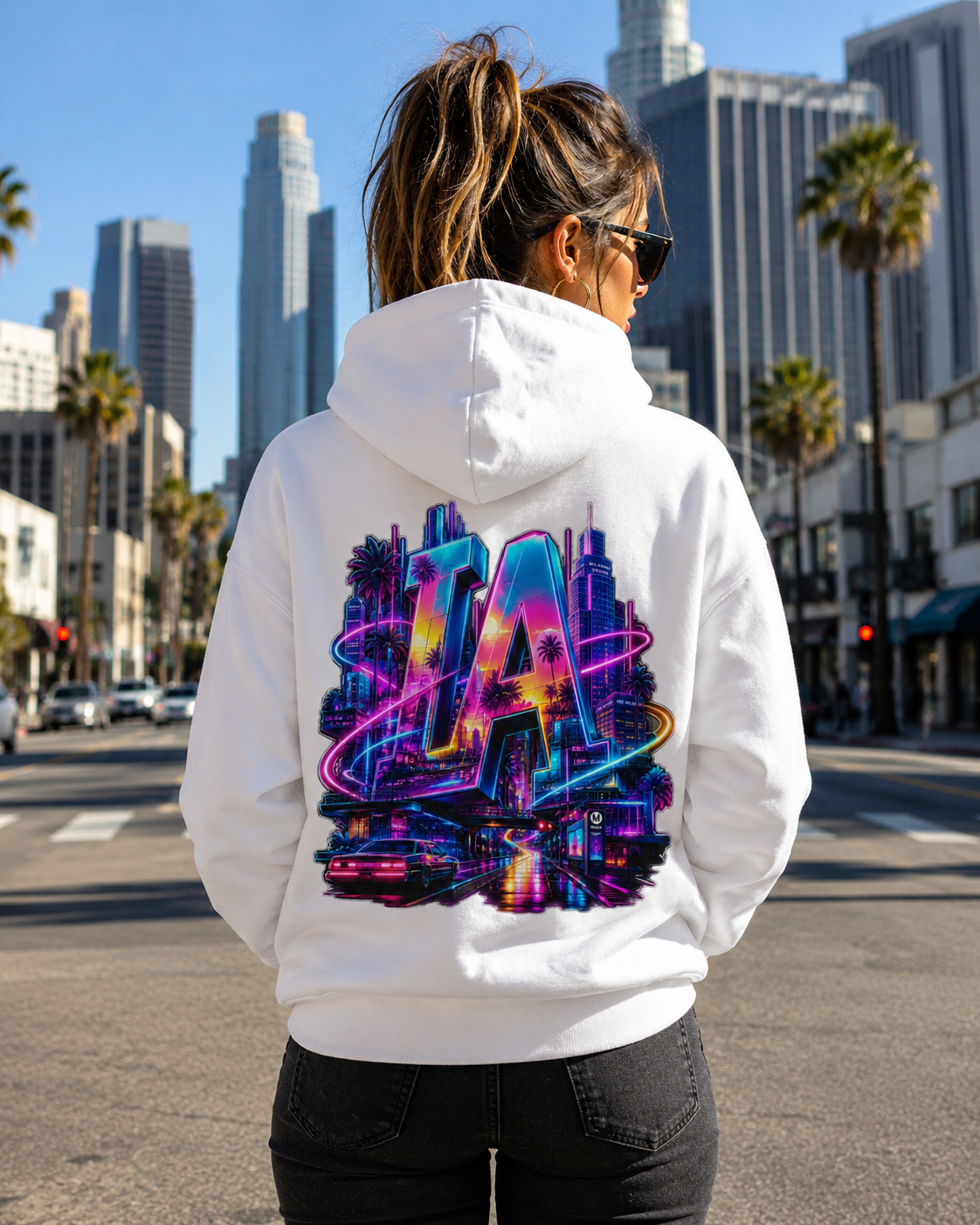 White hoodie worn outdoors, back view with neon LA city graphic and hood