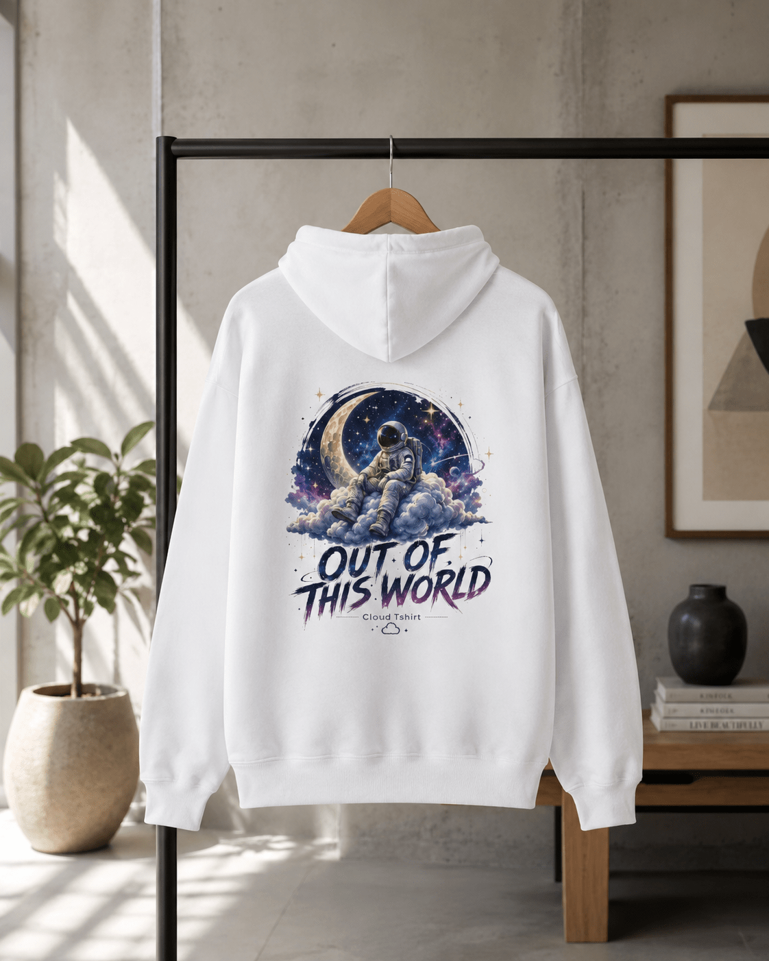 White hoodie on hanger with front astronaut space graphic and "Out of This World" text