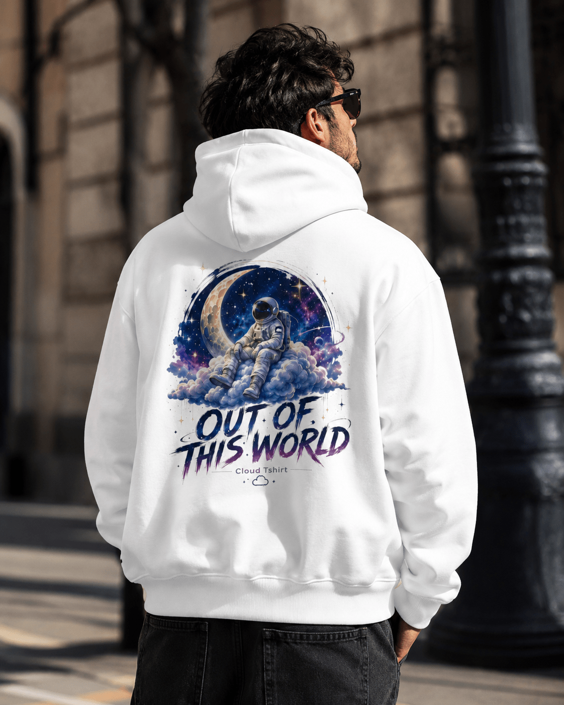 White hoodie, back view on person with astronaut space graphic and "Out of This World" text
