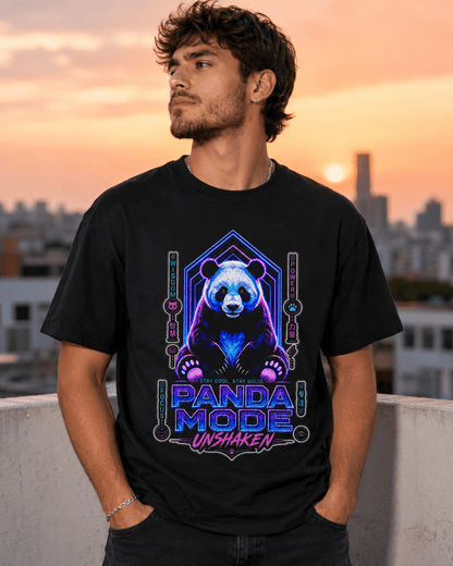 A man wearing a black graphic t-shirt with a neon panda design and the text 'PANDA MODE UNSHAKEN' stands on a rooftop at sunset.
