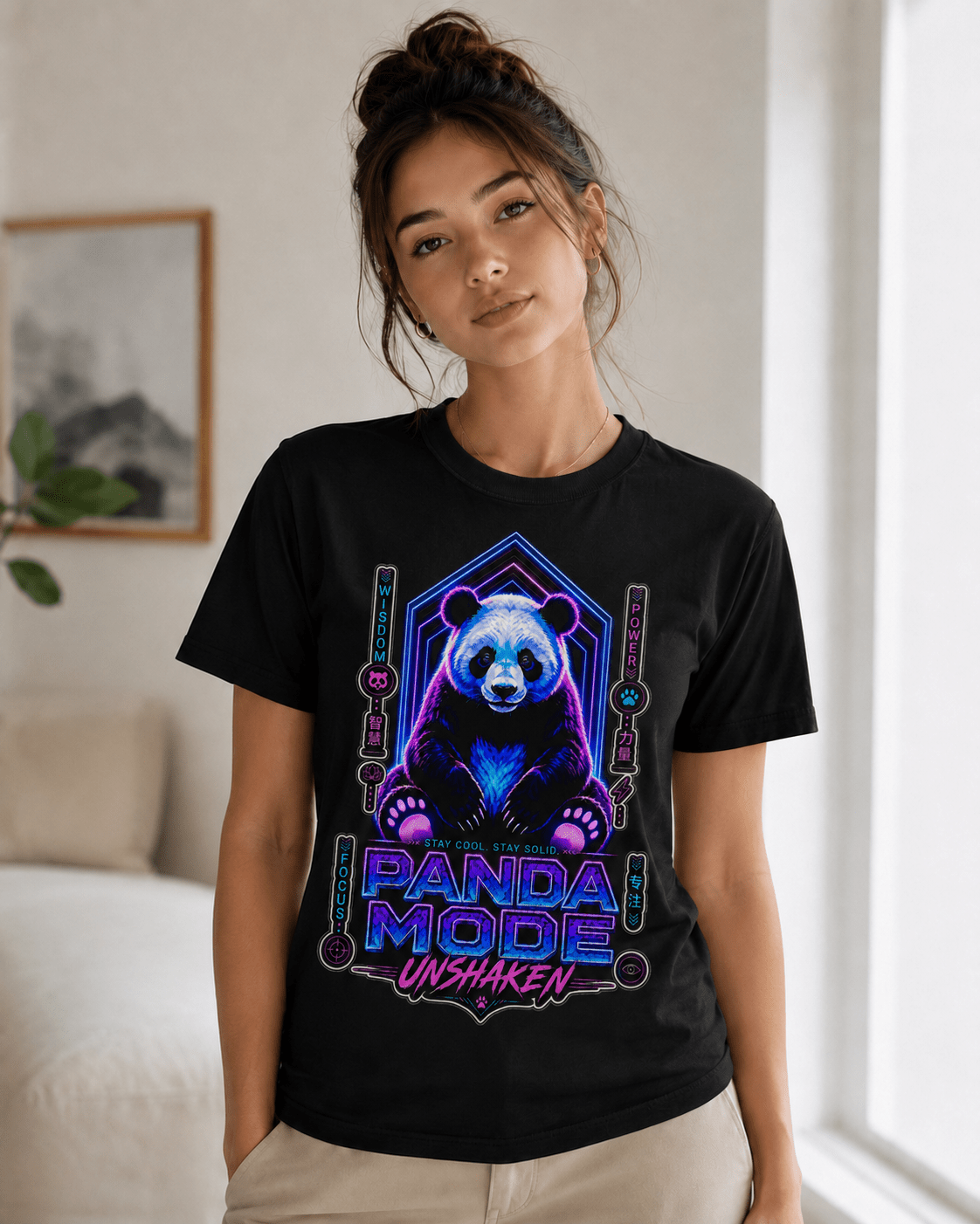 A woman wearing a black short-sleeve graphic t-shirt with a colorful neon panda design and the text 'PANDA MODE UNSHAKEN'.