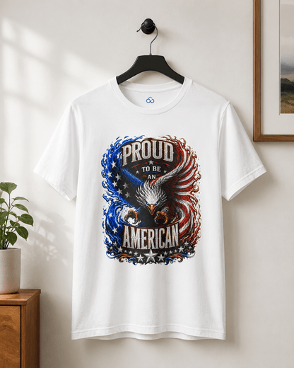A white short-sleeve crewneck t-shirt hanging on a black hanger against a light beige wall. The shirt features a large patriotic graphic of an eagle with its wings spread, surrounded by the text 'PROUD TO BE AN AMERICAN' in distressed lettering, with blue and red flag-inspired swirls and stars.