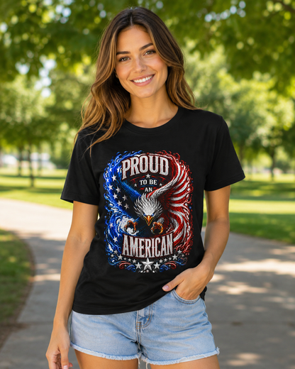 A woman wearing a black graphic t-shirt with a patriotic eagle design and the text 'PROUD TO BE AN AMERICAN', paired with light blue denim shorts, standing outdoors on a park path.