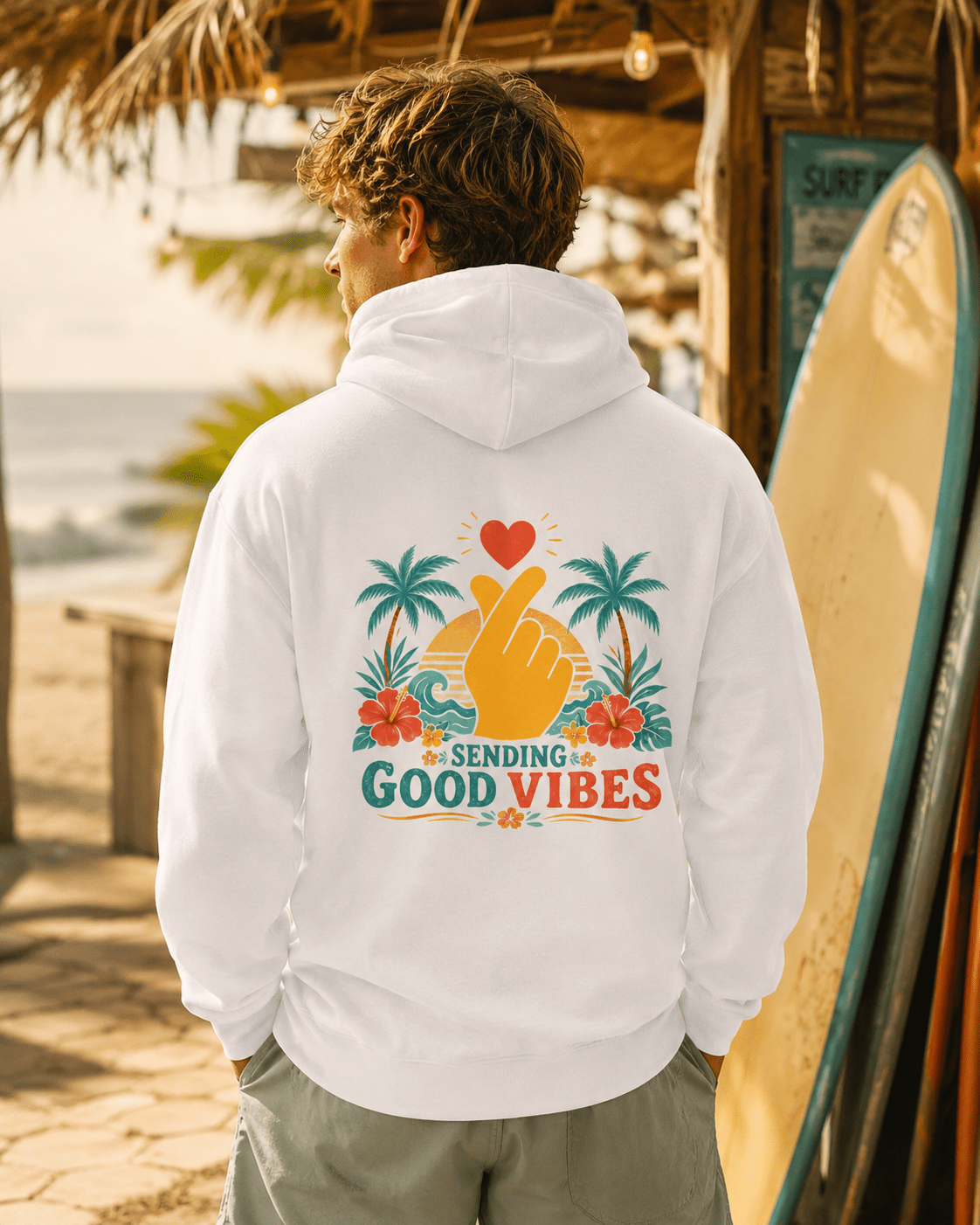 White hoodie with hood and back Good Vibes palm-heart graphic, worn from behind