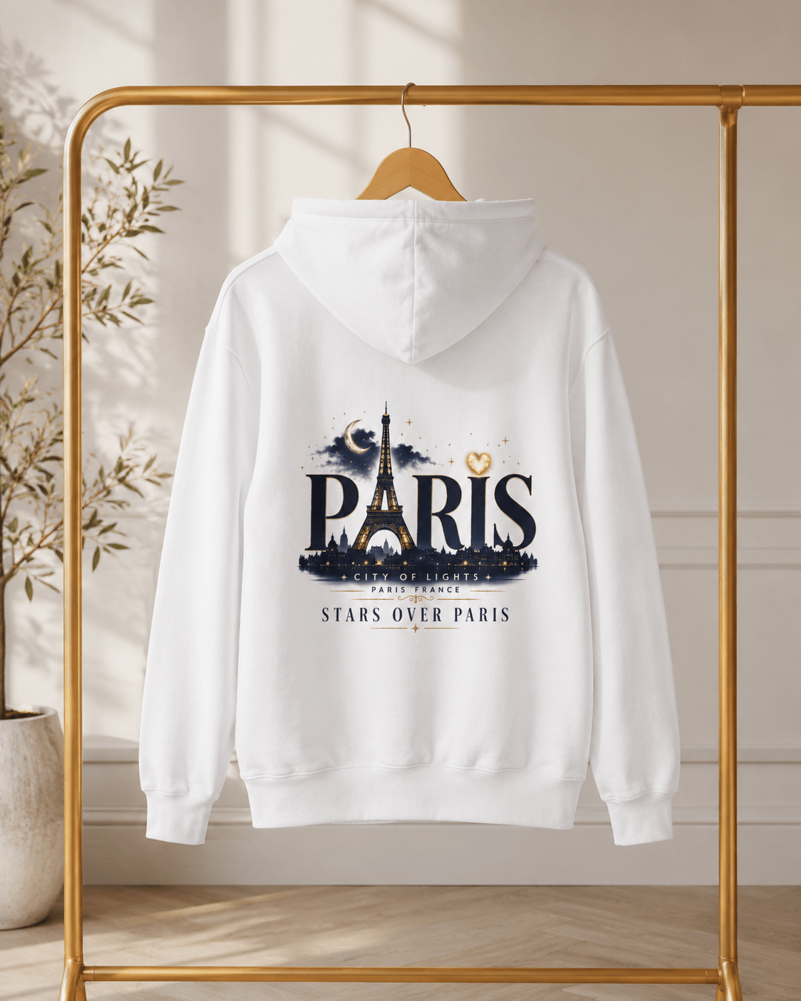 White Paris hoodie on hanger with back graphic featuring Eiffel Tower and stars