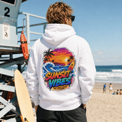 White pullover hoodie with back sunset graphic, worn on a sandy beach