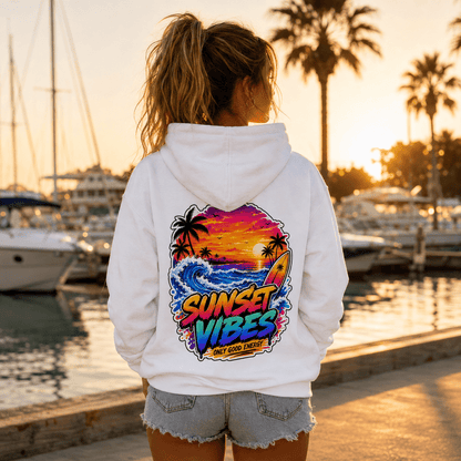 White hoodie with back sunset graphic, model standing near marina at sunset