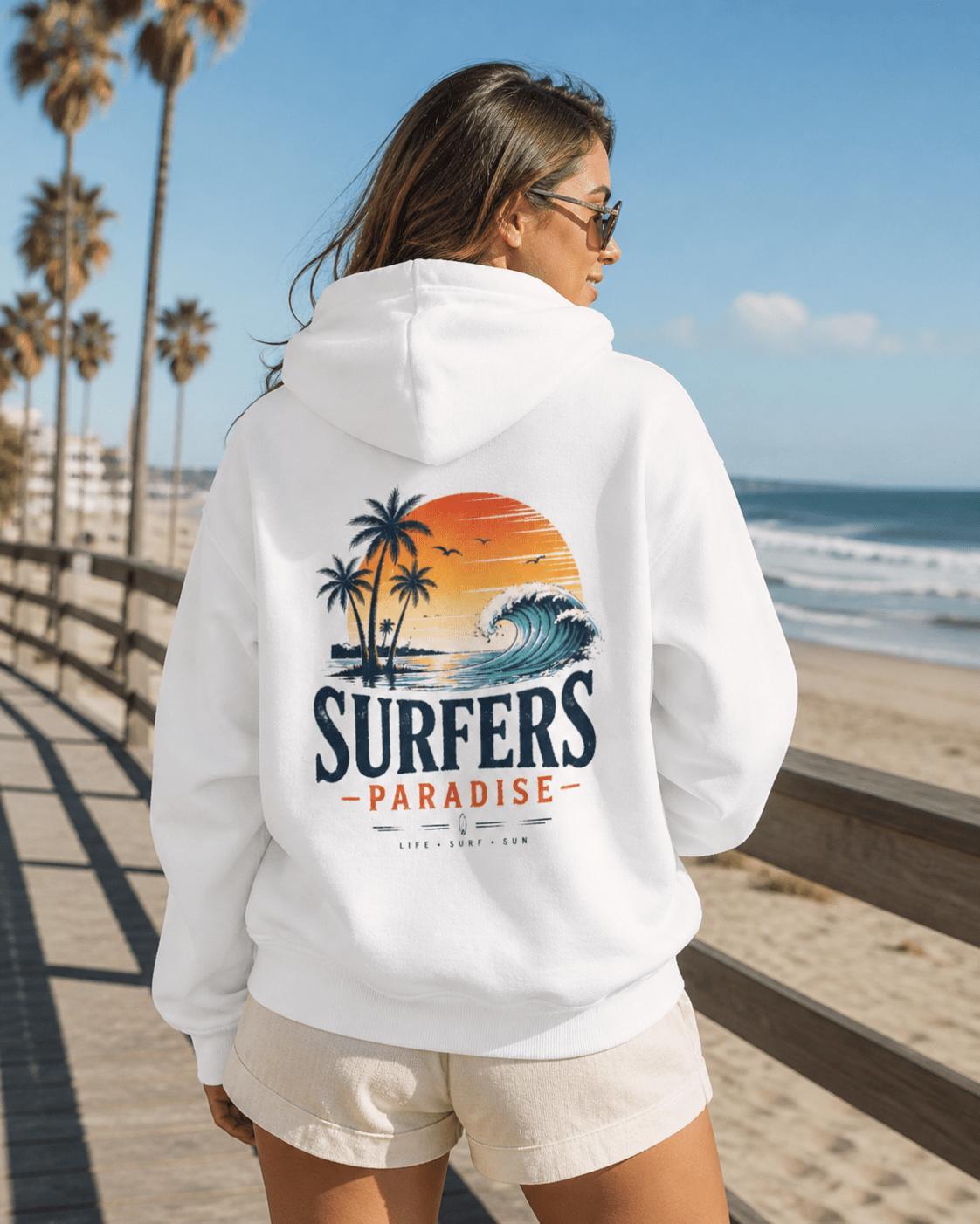 White pullover hoodie worn from back, hood up; surf-themed palm and wave print