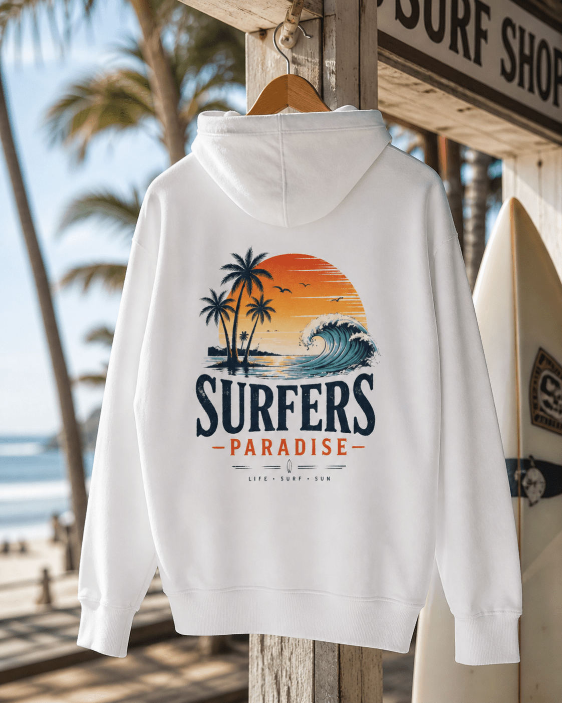 White pullover hoodie on hanger; surf-themed back graphic with palms, sunset and wave