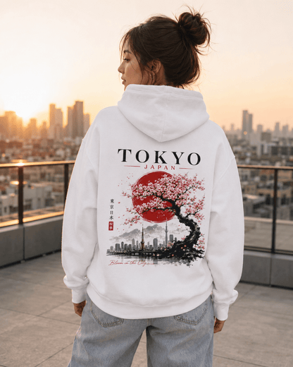 White hoodie on model with back TOKYO JAPAN cherry tree skyline print, sunset.
