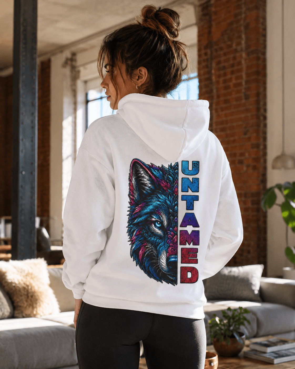 White pullover hoodie on model, wolf graphic and vertical UNTAMED print