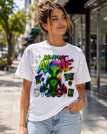 White graphic T-shirt worn by woman outdoors, alien head and colorful front print